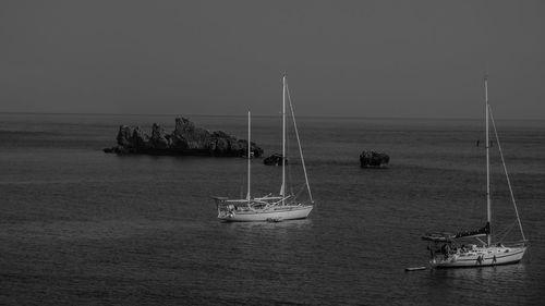 Sailboat sailing on sea against clear sky