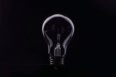 Close-up of light bulb against black background