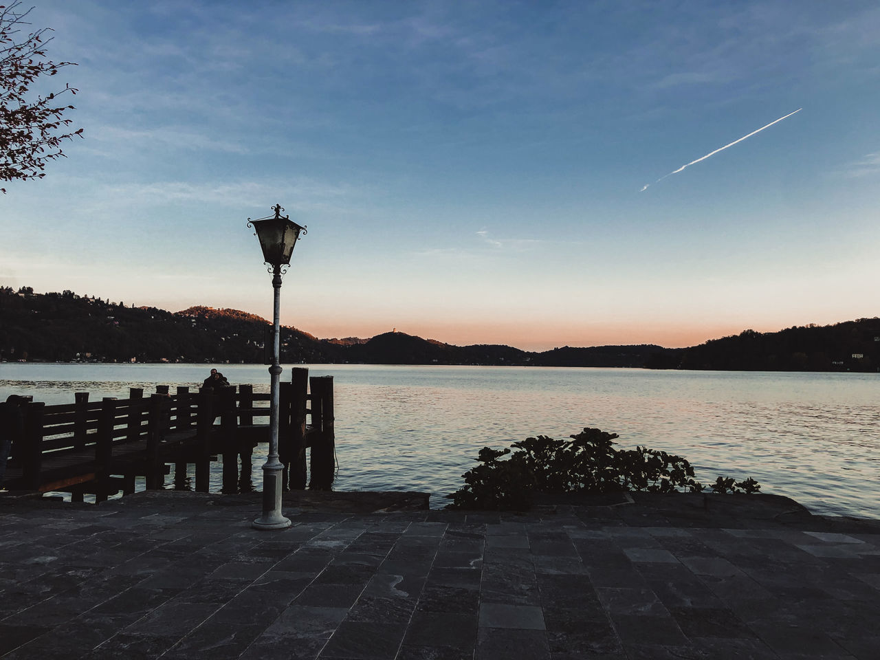 SILHOUETTE STREET LIGHT BY LAKE AGAINST SKY