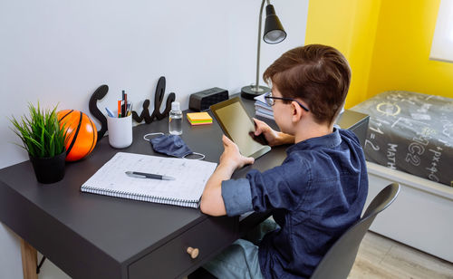 High angle view of boy using digital tablet at home