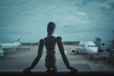 Close-up of airplane on airport runway against sky