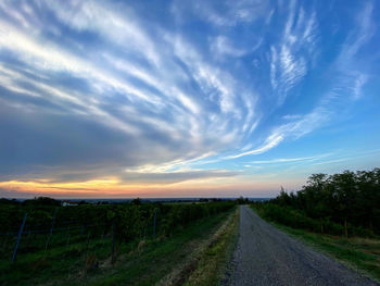 Road amidst landscape against sky during sunset