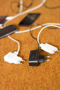 Close-up of mobile phone and chargers on table