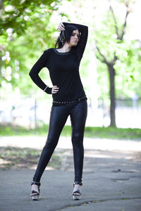 Portrait of young woman standing on road