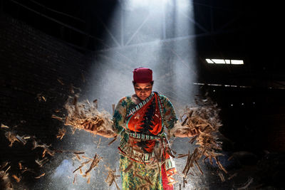 Man holding umbrella standing at night