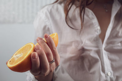 Midsection of woman holding oranges