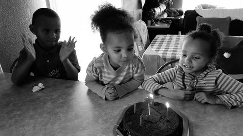 Siblings looking at cake in home