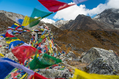 Multi colored umbrellas on rock against sky