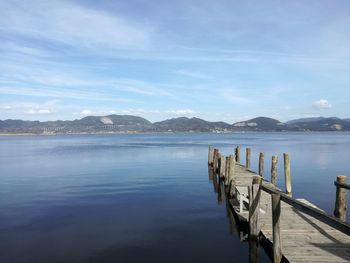 Wooden pier in lake against sky