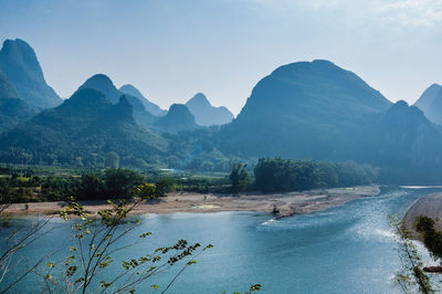 Scenic view of river with mountain range in background
