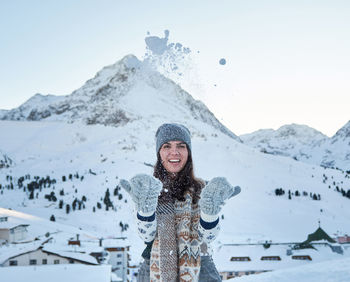 Winter portrait of a young woman, snow, mountain, outdoors, happy.