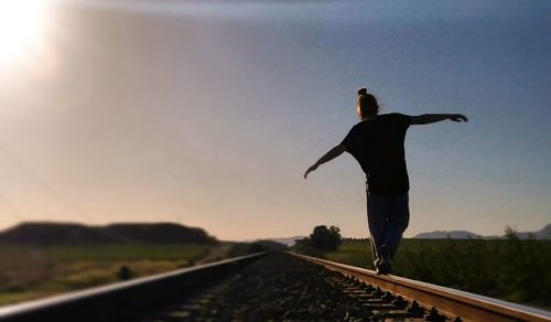 Man standing on railroad track against sky