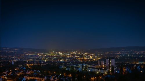 Illuminated cityscape against sky at night