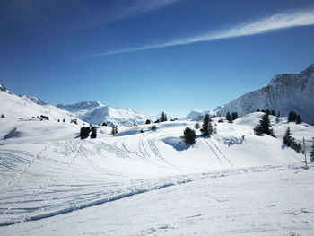 Scenic view of snowcapped mountains against blue sky