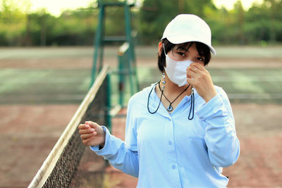 Portrait of a woman wearing mask on tennis court