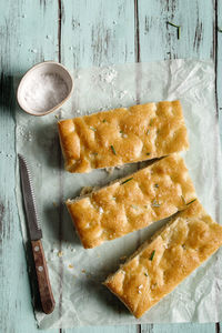 Slice of italian focaccia, on wooden table.