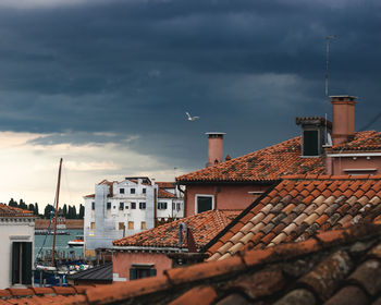 Buildings in city against cloudy sky