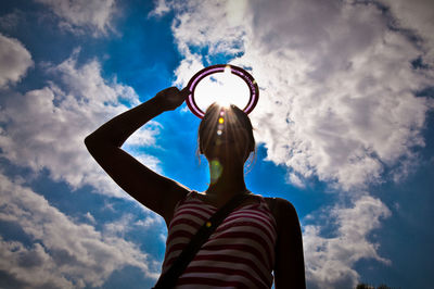 Low angle view of people against cloudy sky