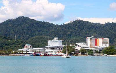 Scenic view of sea by buildings against sky