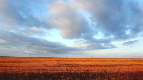 View of fields against cloudy sky
