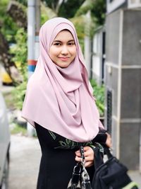 Portrait of smiling young woman standing outdoors