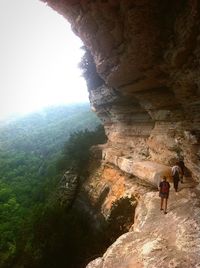 Rear view of man on rock formation in cave