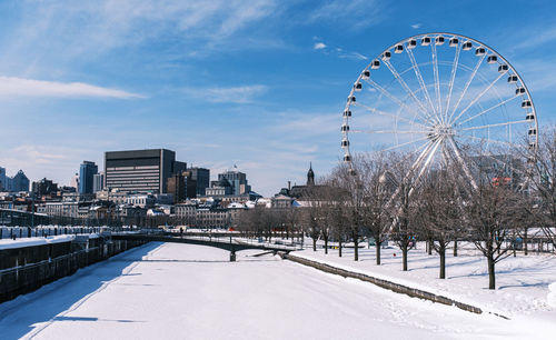 Ferris wheel in city against sky during winter