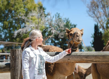 Smiling woman looking at camels