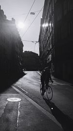 Bicycle on city street by buildings against sky