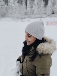 Woman wearing hat standing in snow