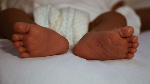 Close-up of baby feet on bed