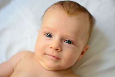 Portrait of cute baby lying on bed