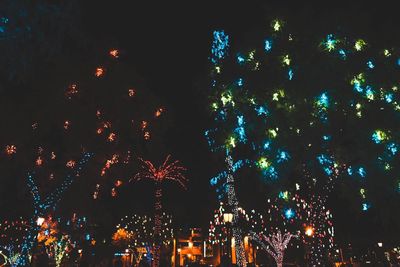 Low angle view of firework display against sky at night