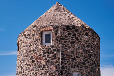 Traditional stone wind mill in imerovigli village, santorini, greece