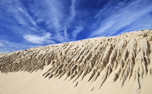 Sand dune in desert against sky