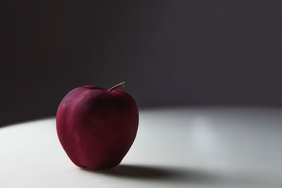 Close-up of apple on table against black background