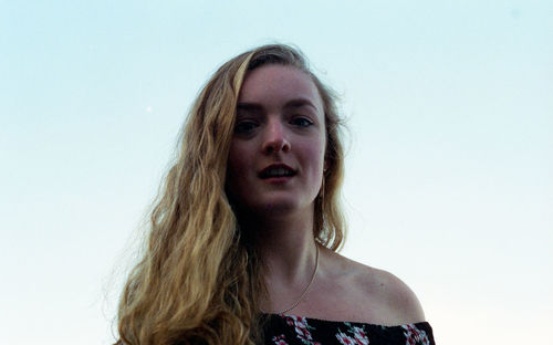 Portrait of young woman against sky