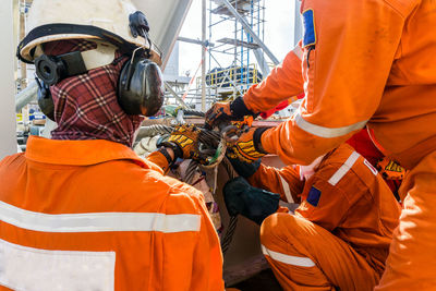 Construction workers preparing sling for heavy lifting of structure frame on a construction barge 