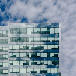 Modern office building against cloudy sky
