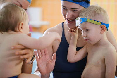 Kids communicating n indoor swimming pool with teacher. happy time together 