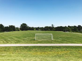 Scenic view of soccer field against clear sky