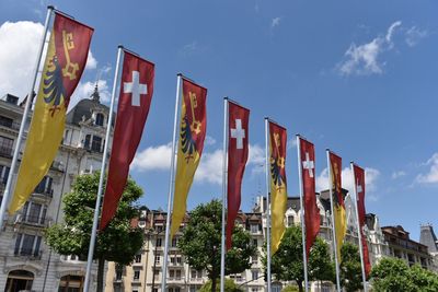Low angle view of flags in city against sky