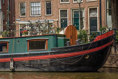 Boats moored in canal by buildings in city