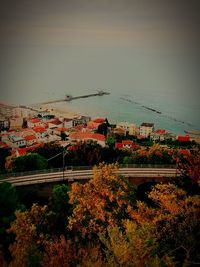 High angle view of buildings by sea against sky