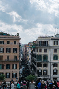 People on street against buildings in city