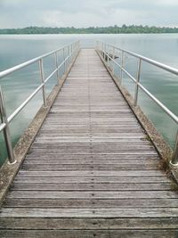 Wooden pier on sea against sky