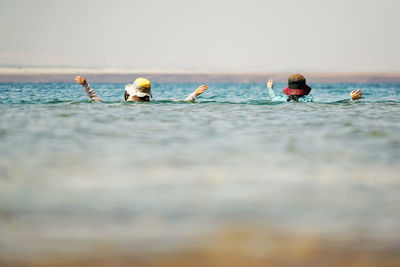 Two women with casual clothing in the sea