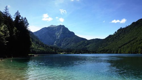Scenic view of lake and mountains against blue sky