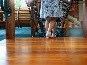 Low section of woman standing on wooden floor