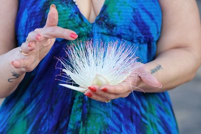 Midsection of woman holding blue flower